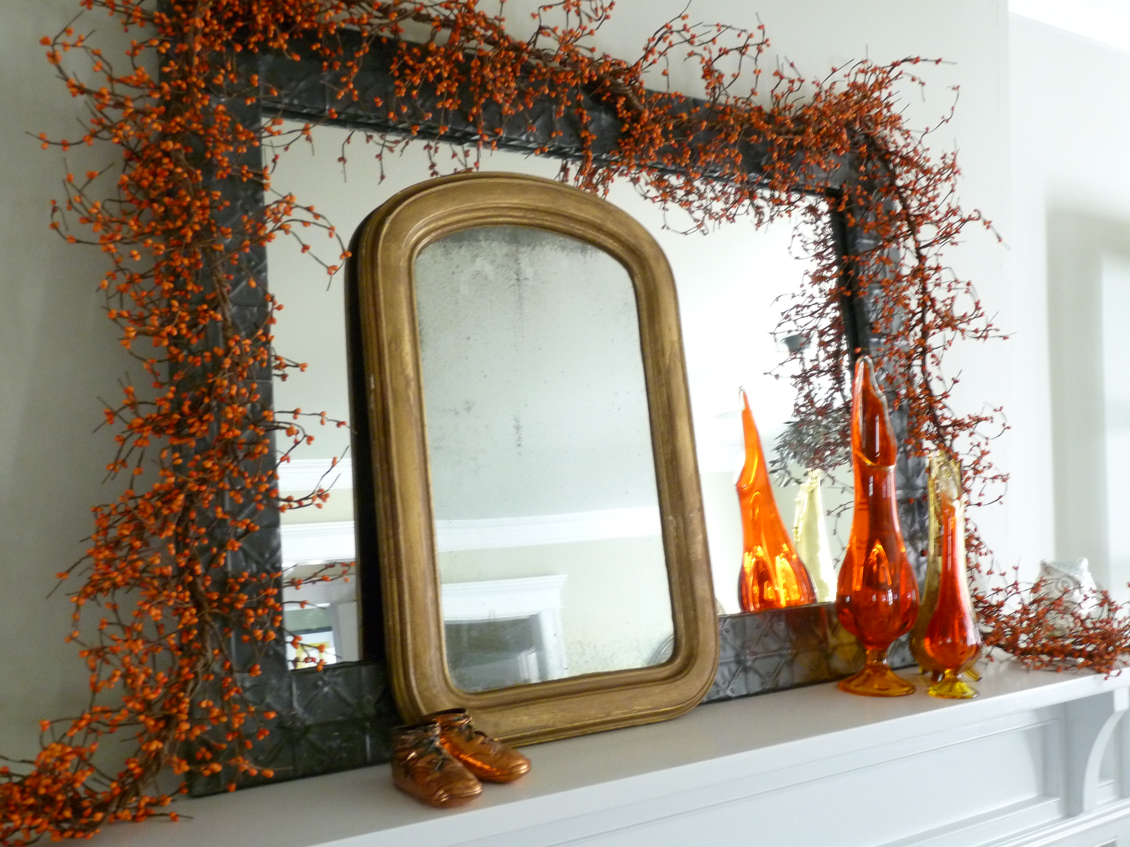 Fall mantel with orange berry garland and vintage mirrors kellyelko.com #falldecor #falldecorating #vintagedecor #fallmantel