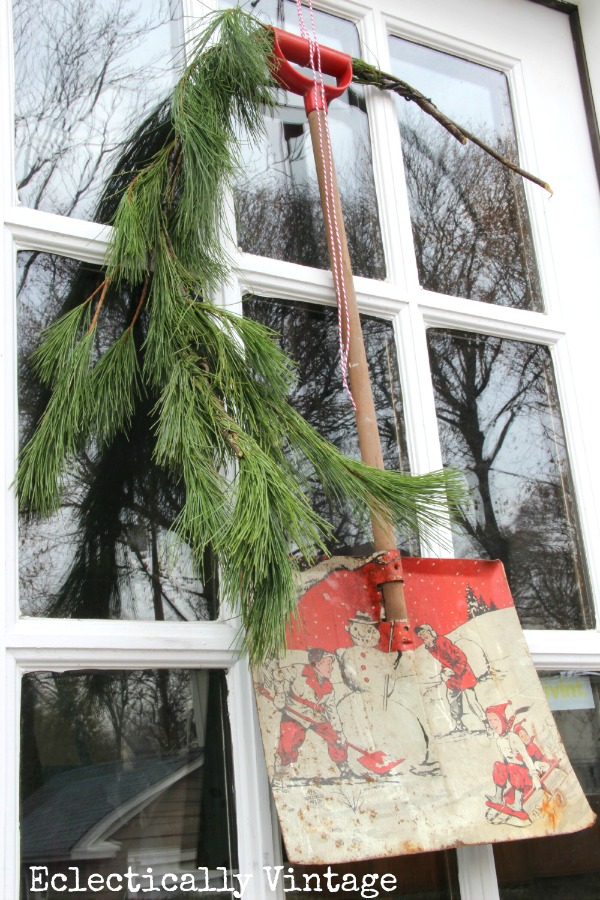 How fun is this vintage child's shovel used as a wreath on the door kellyelko.com #vintagechristmas #christmasdecor #christmasweath #vintage #wreaths #kellyelko