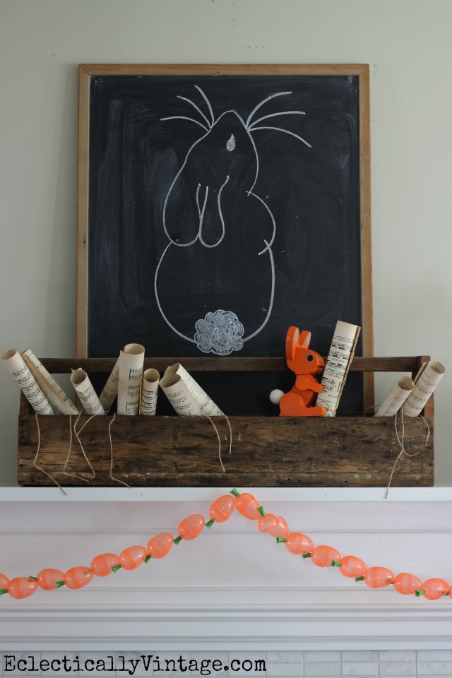 Cute spring mantel with bunny chalkboard, old toolbox and carrot garland kellyelko.com