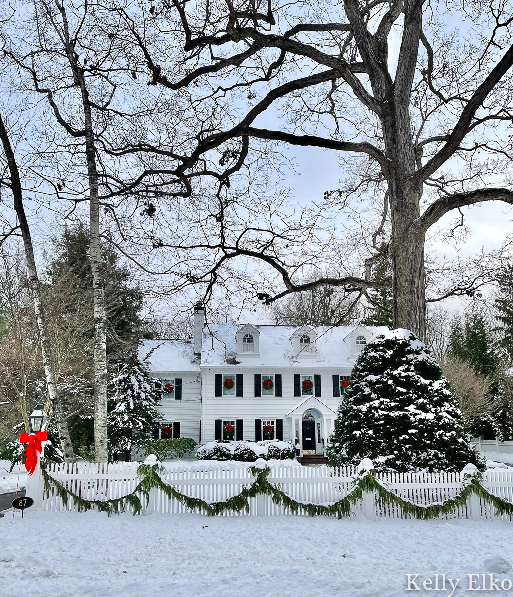 Love this classic white house with picket fence in the snow kellyelko.com