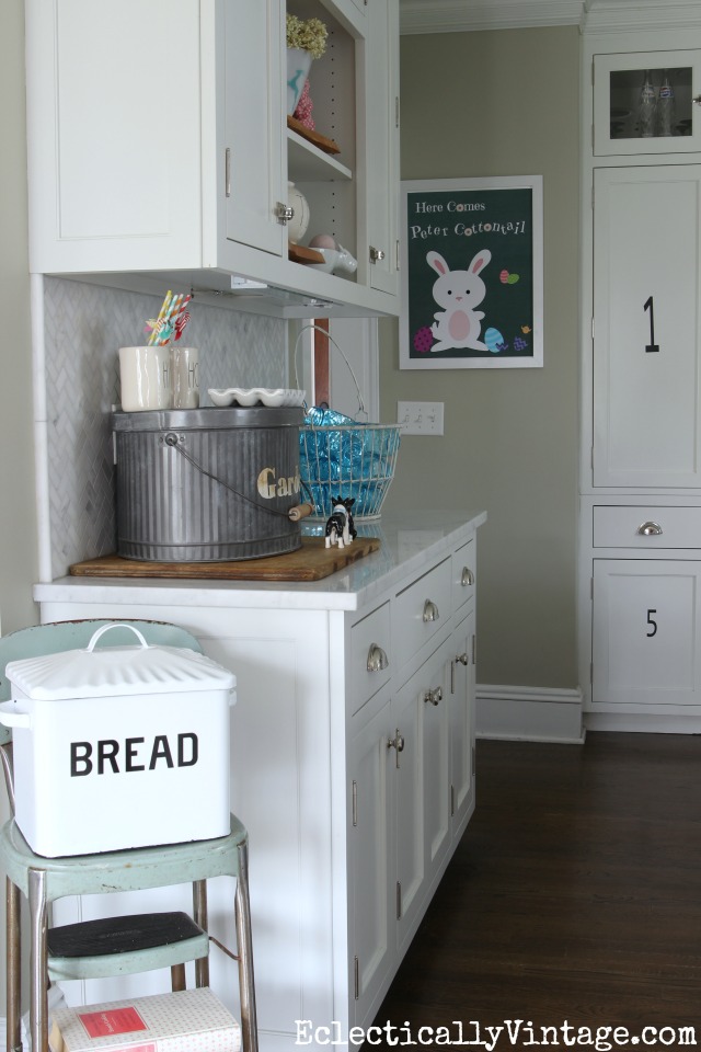 Spring kitchen - love the old step stool with the bread box kellyelko.com #spring #springdecor #springdecorating #springcrafts #hometour #housetour #eclectichome #farmhousedecor #fixerupperstyle #jadeite #farmhousestyle #vintagedecor #vintagehome #kellyelko #whitekitchen #breadbox #vintagedecor 