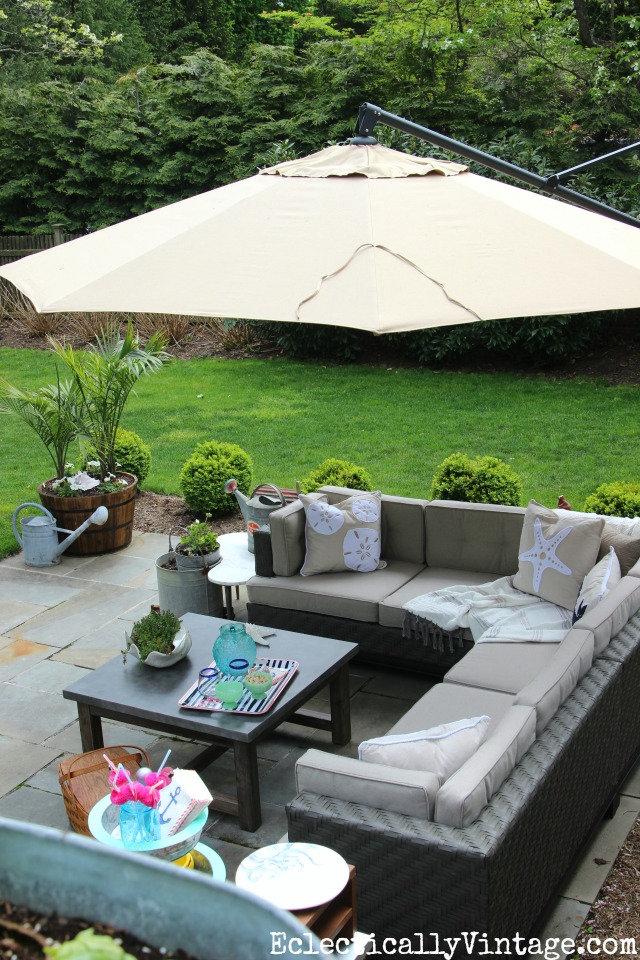 Beautiful patio makeover - love the outdoor sectional and the concrete topped coffee table kellyelko.com #patio #patiofurniture #patiomakeover #outdoorliving #backyard #outdoorfurniture #outdoormakeover #bluestone 