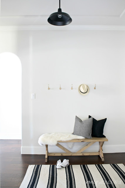 Love the simplicity of a black and white foyer with hooks for storage kellyelko.com