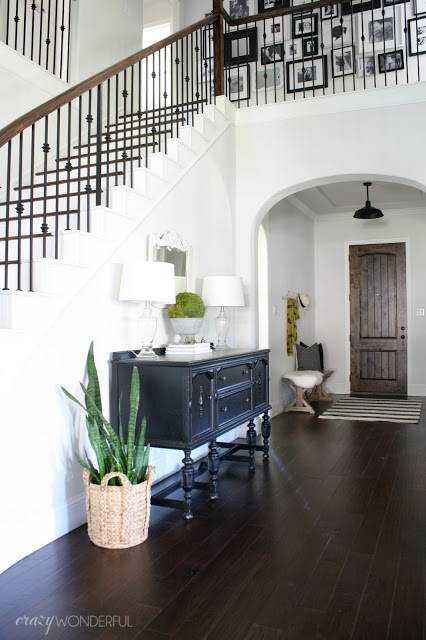 Grand entry foyer with iron bannister and vintage table kellyelko.com