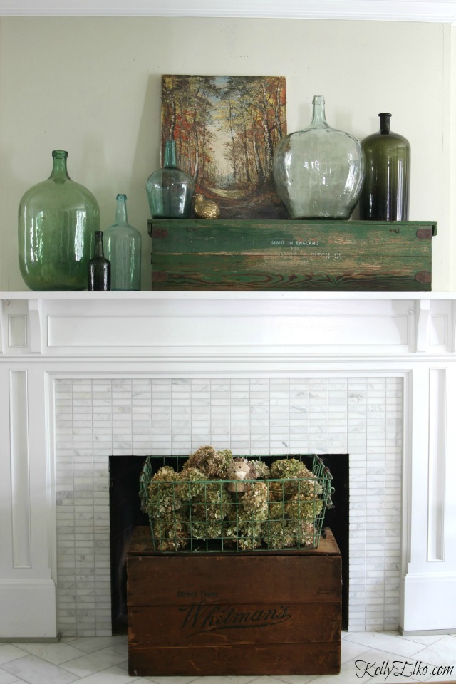 8 Creative Fall Mantel Decor Ideas - love the vintage demijohns, landscape painting and crate filled with dried hydrangeas kellyelko.com #fall #falldecor #falldecorating #fallmantel #manteldecor #vintagedecor #eclecticdecor 