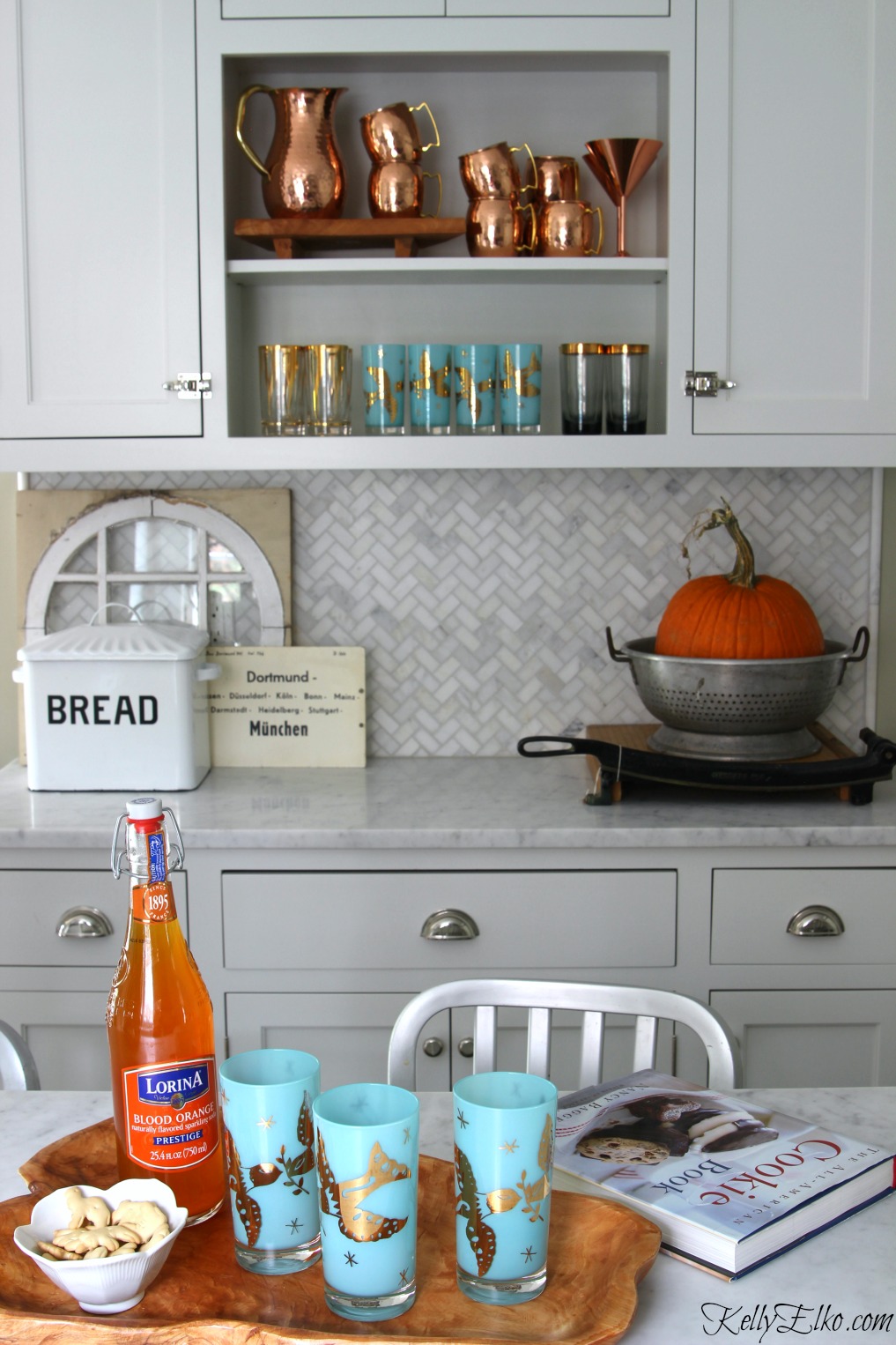 Love the open kitchen shelves with copper mugs and vintage drinking glasses on display kellyelko.com