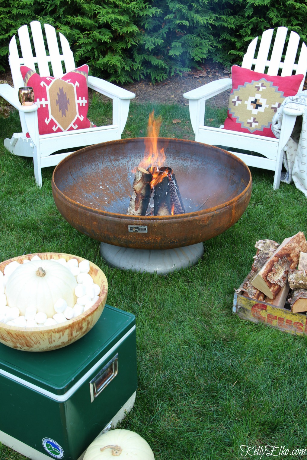 Cozy fall fire pit - I love the red boho pillows and vintage finds like the old cooler and soda crate holding kindling kellyelko.com