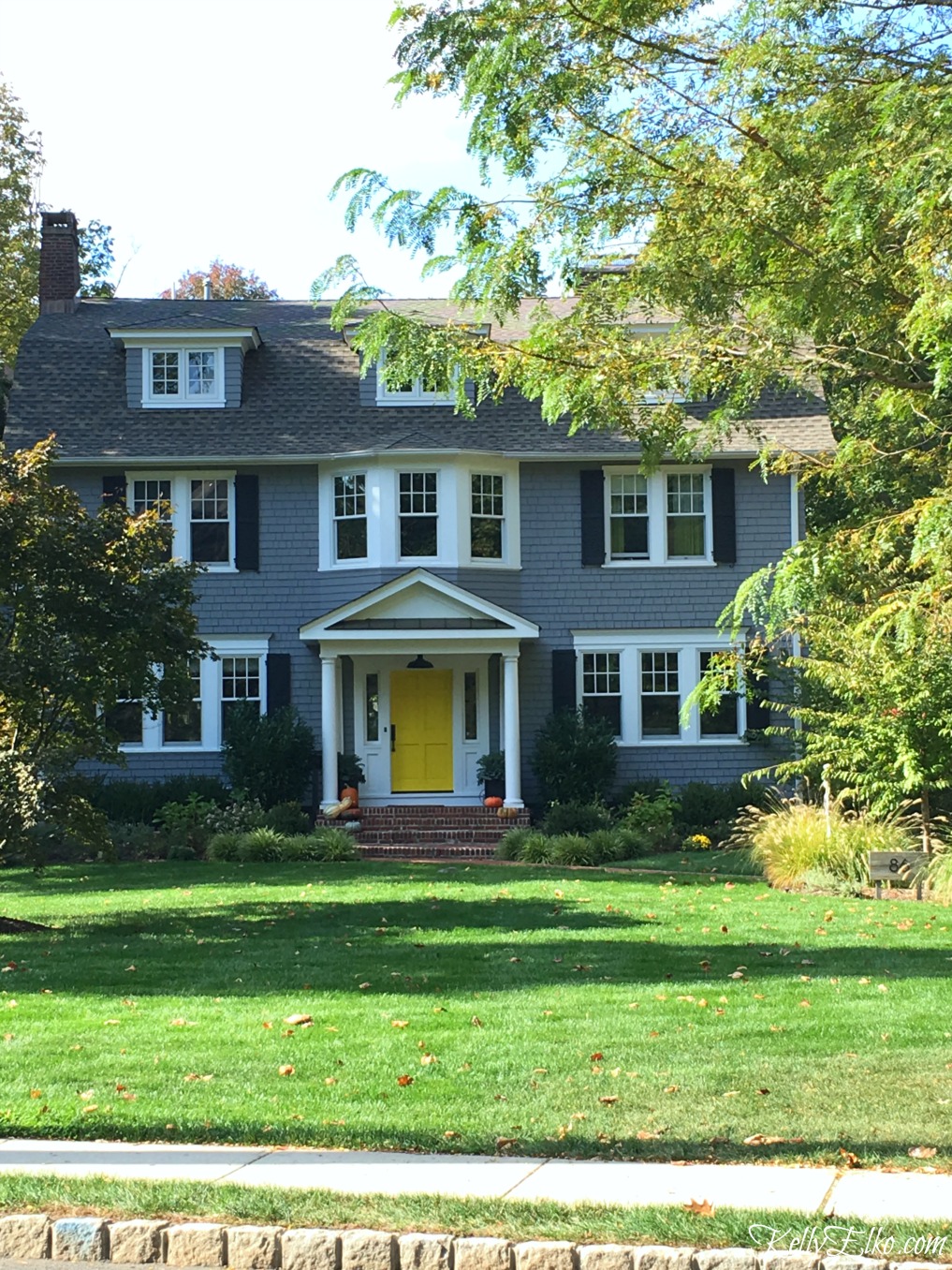 Love the fun yellow front door on this charming blue house - see more fall homes with curb appeal kellyelko.com