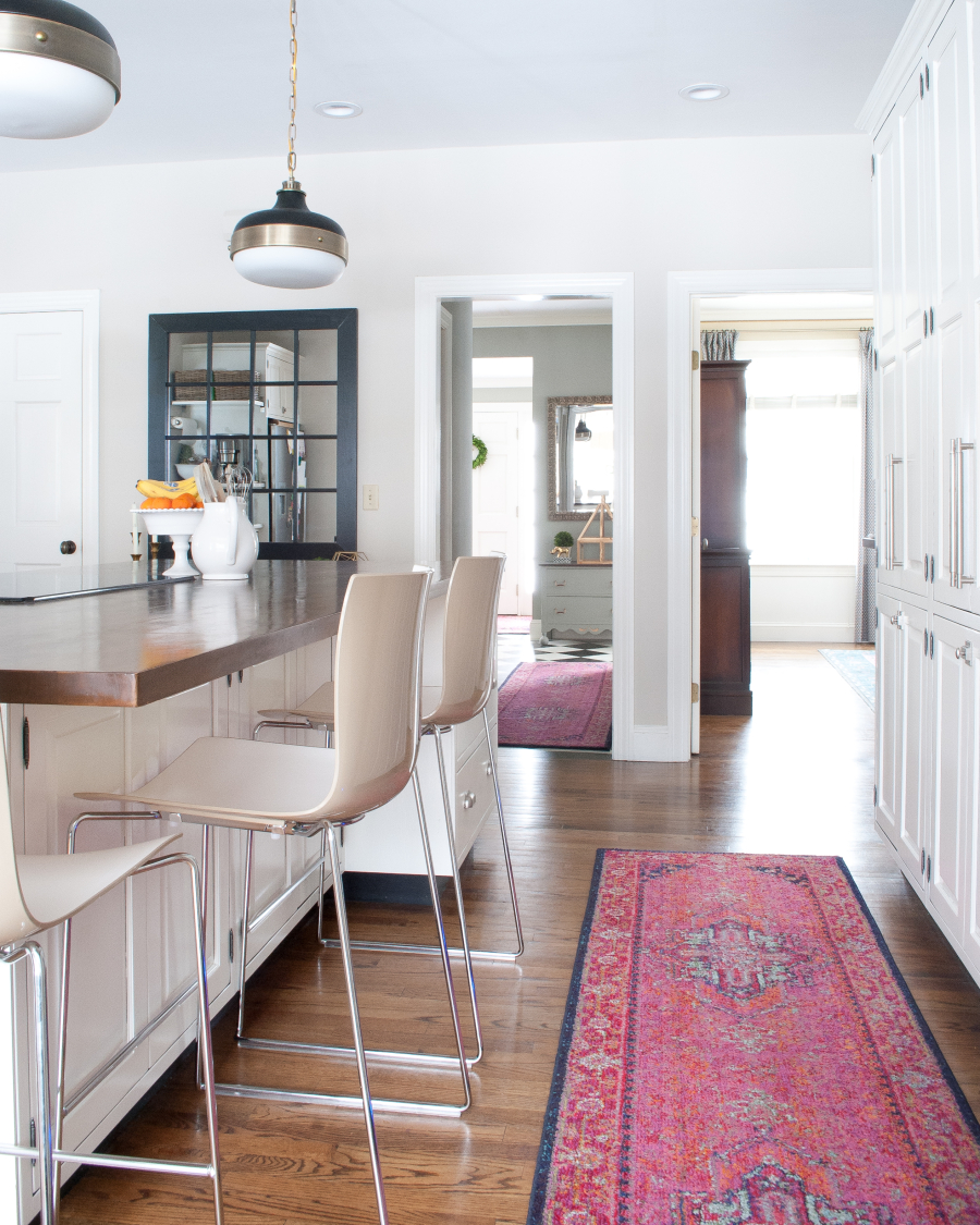 Love the pink Oriental rug in this white kitchen 