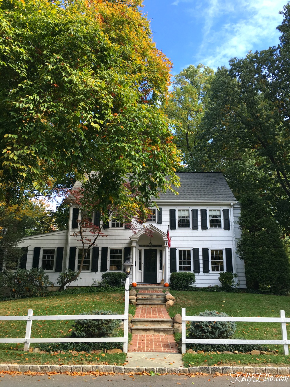 Love this classic white colonial house behind a picket fence - see more fall homes with curb appeal kellyelko.com