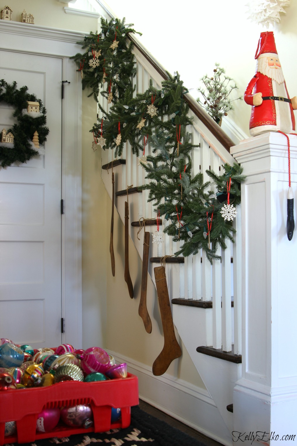 Love this lush Christmas garland on the staircase with wood snowflake ornaments kellyelko.com