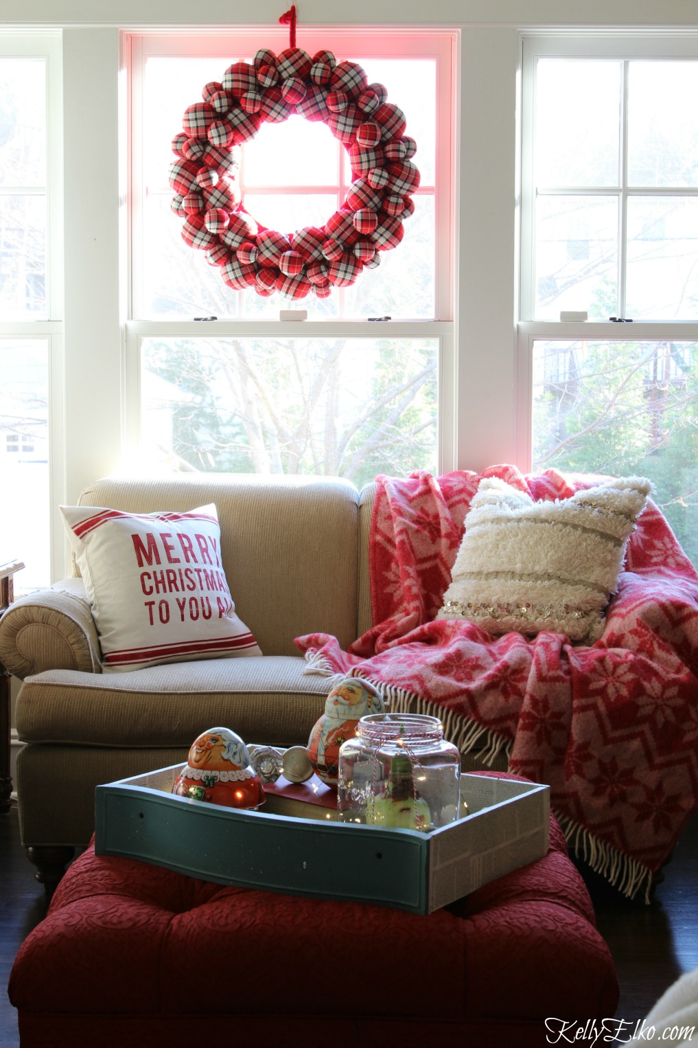 Cozy Christmas family room - love the huge plaid wreath and red snowflake throw blanket kellyelko.com