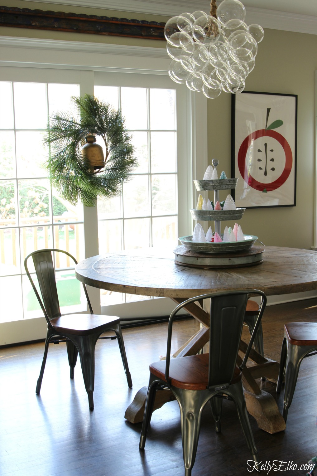 Love the wreath with brass bell in this festive Christmas kitchen ... and that bubble chandelier is amazing! kellyelko.com