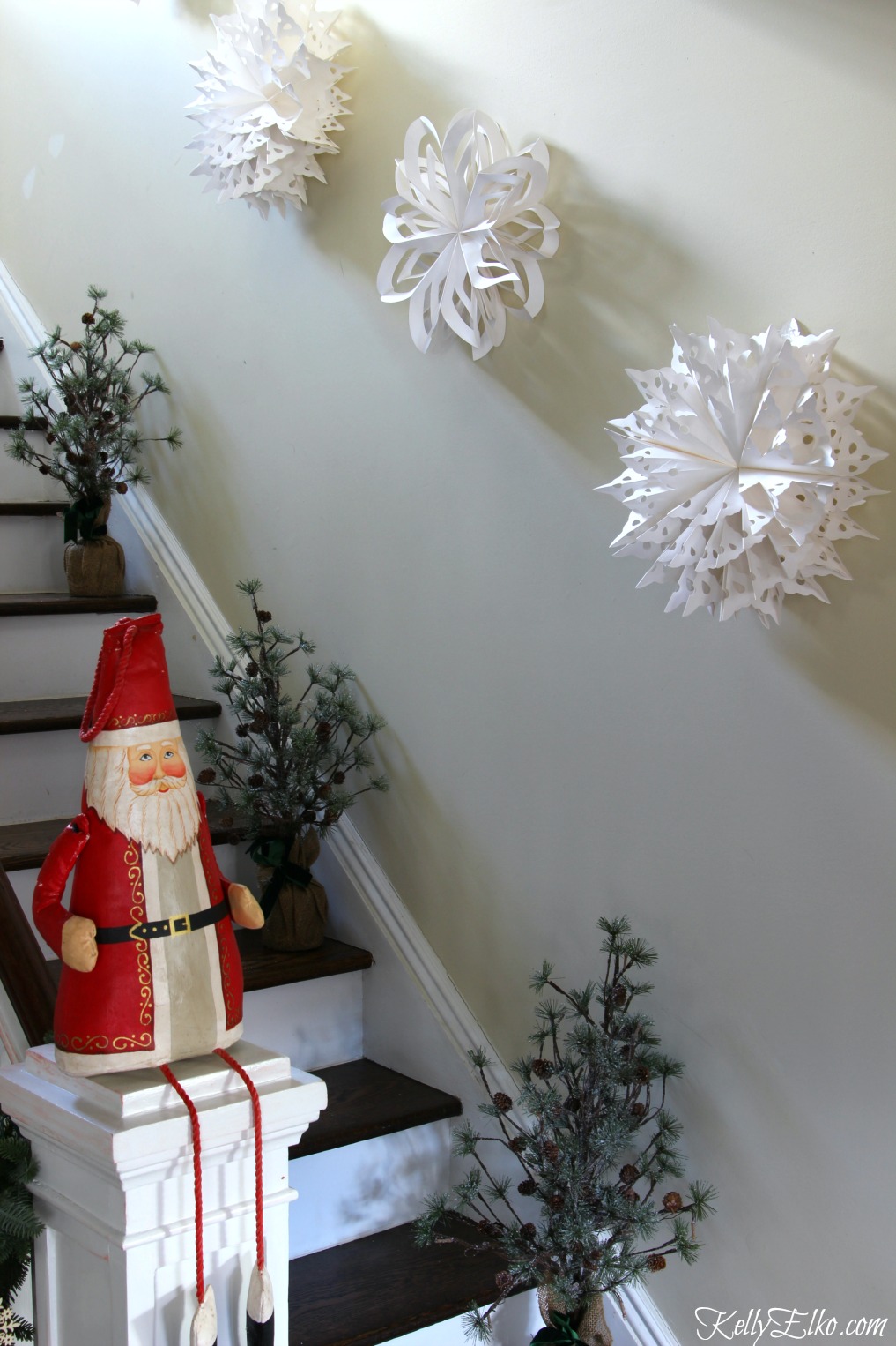 Giant paper snowflakes look amazing on the staircase wall kellyelko.com