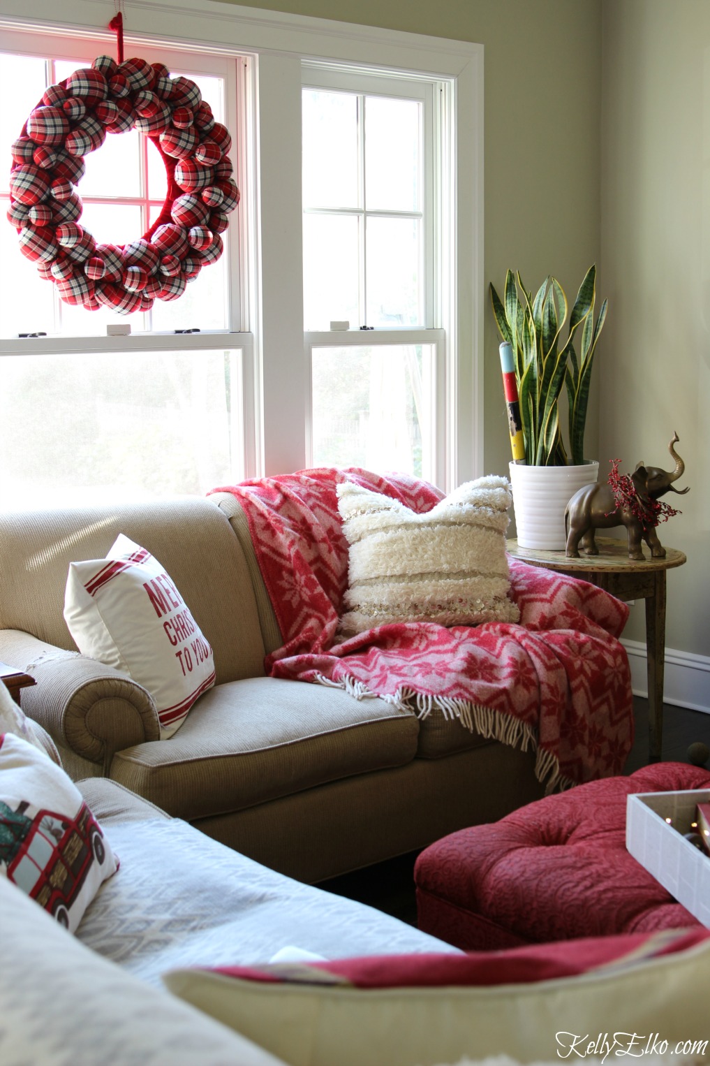 Love this festive red Christmas family room and the giant plaid wreath kellyelko.com