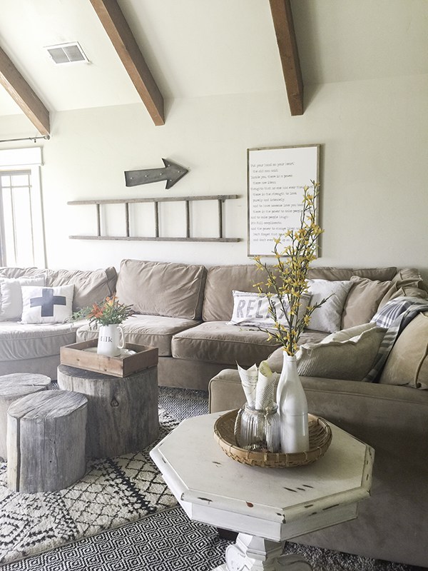 Cozy family room with sectional sofa, layered rugs and log slice coffee table