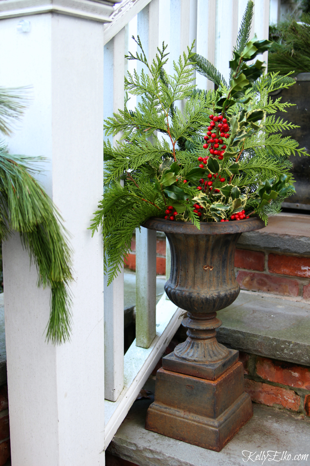 Christmas porch with fresh greens in an antique urn kellyelko.com