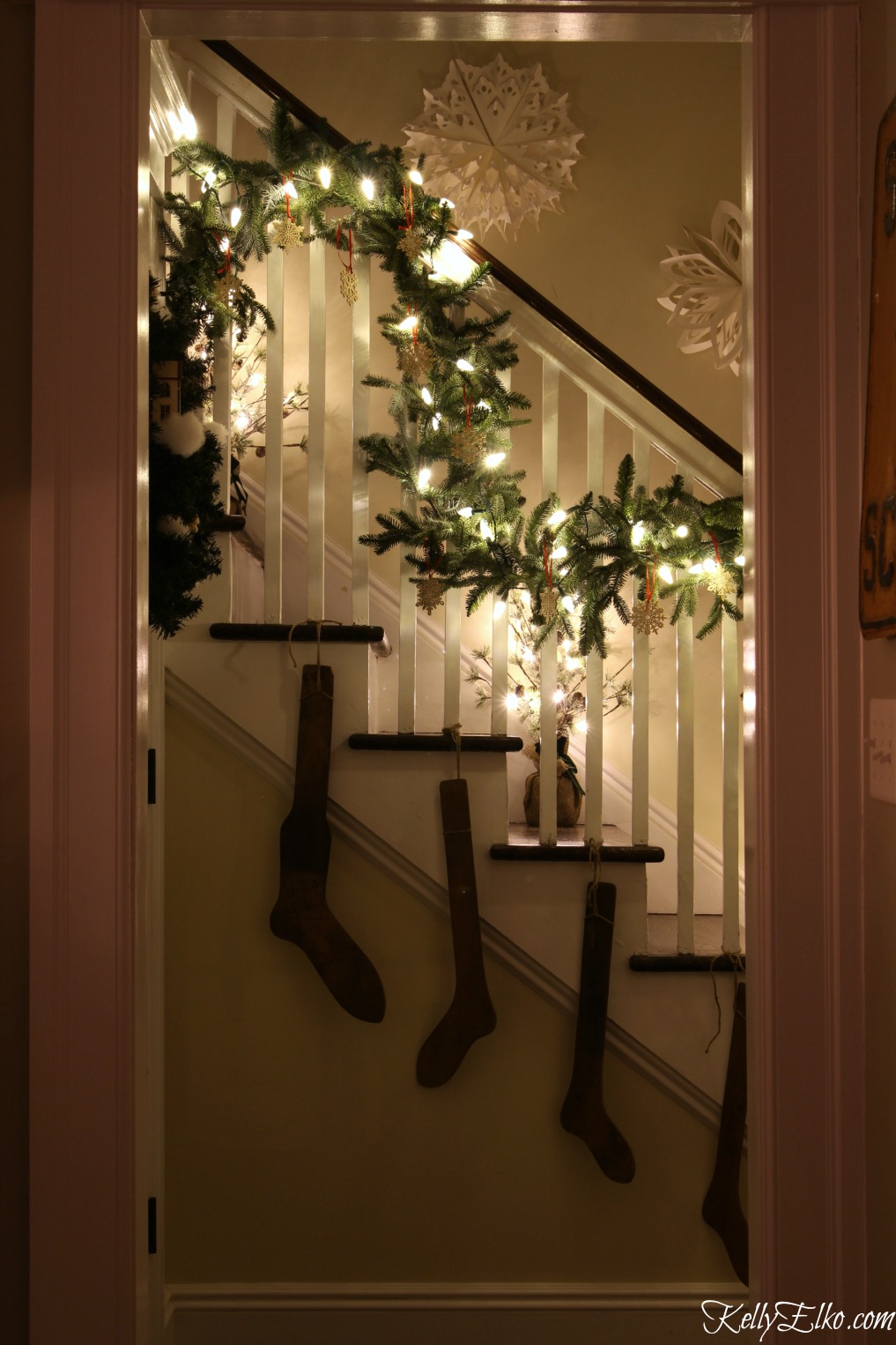 Christmas Lights at Night Home Tours - 35 homes by the glow of light - love this gorgeous banister with garland and stocking stretchers kellyelko.com