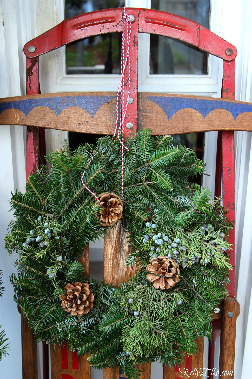 Vintage sled with wreath on this welcoming front porch kellyelko.com