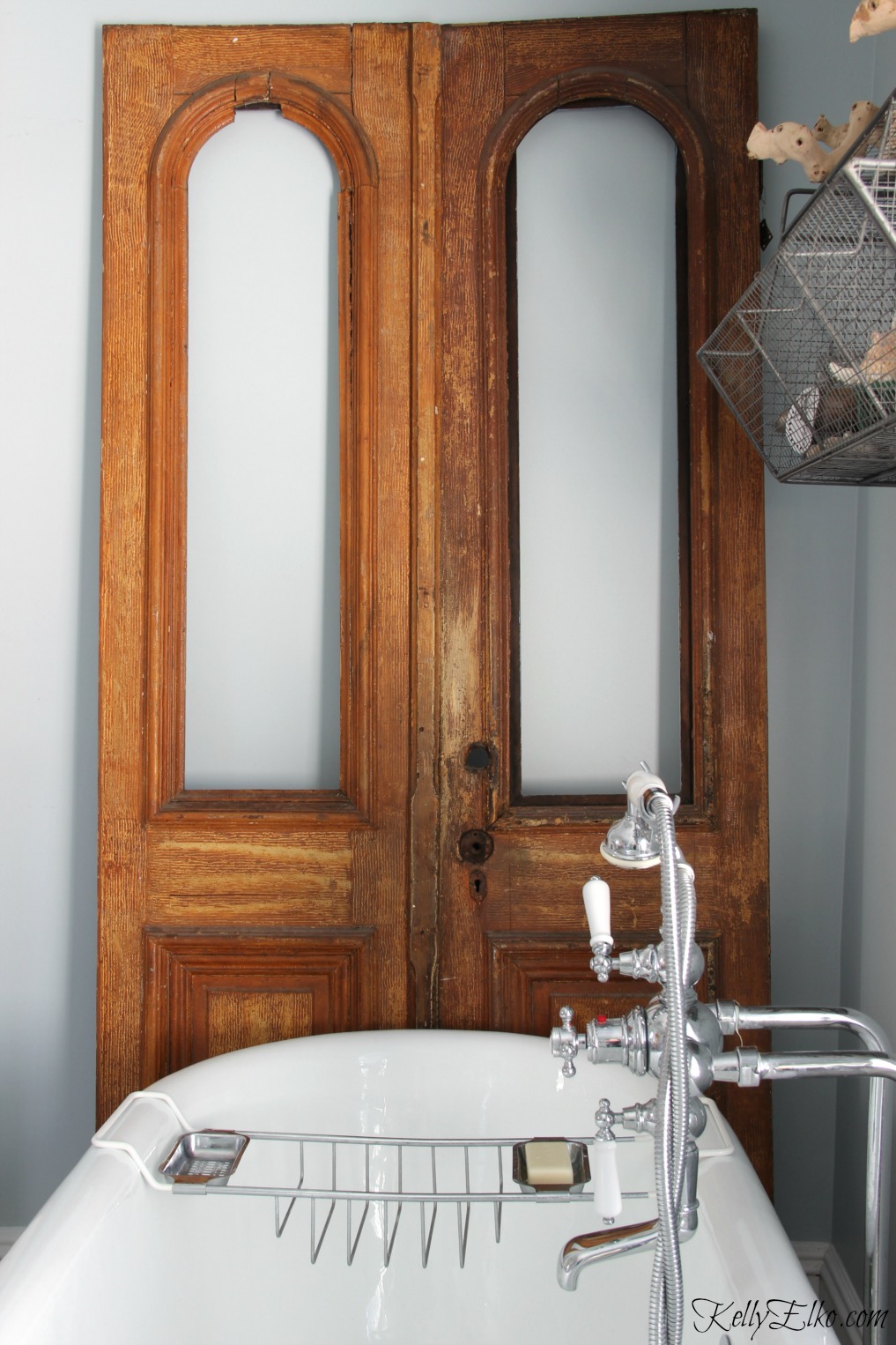 Add antique pieces to a bathroom to add warmth - love these antique arched doors kellyelko.com