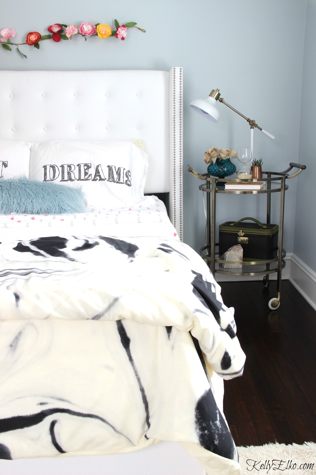 Glam bedroom makeover - love the blue paint, white tufted bed and bar cart as a nightstand kellyelko.com