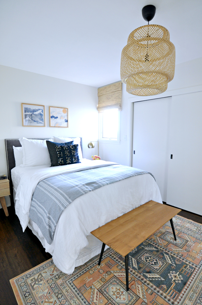 Guest bedroom with kilim rug and woven chandelier