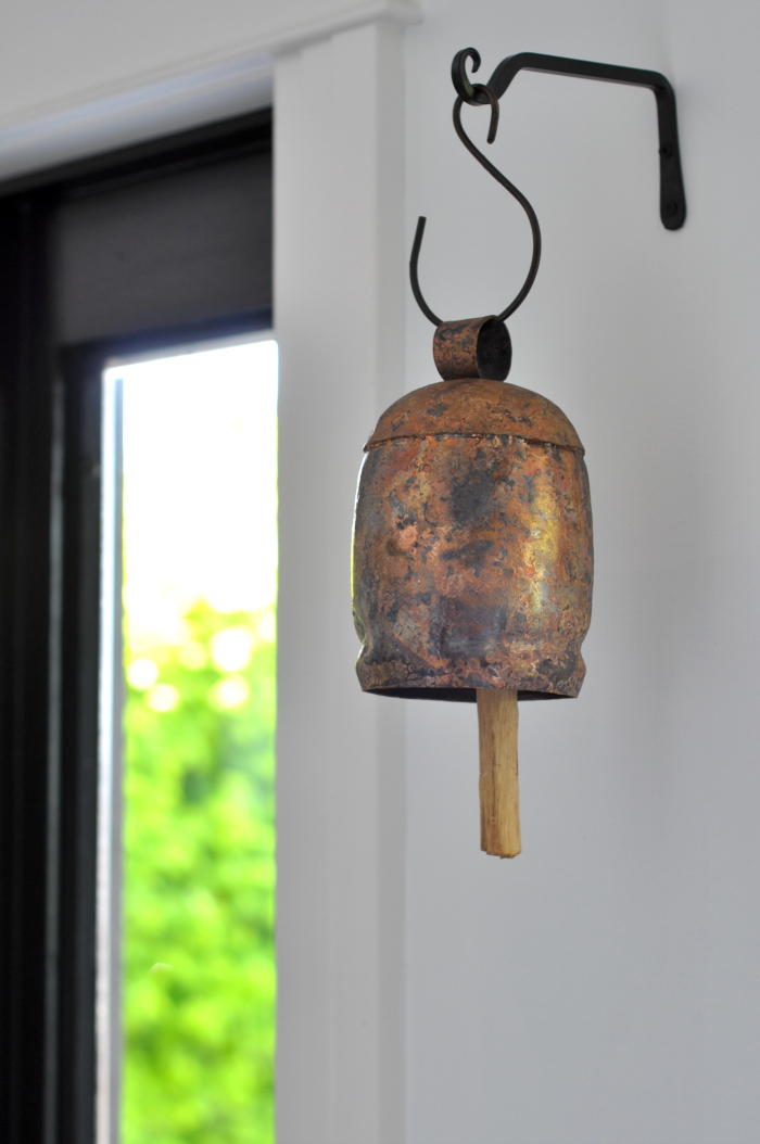 Copper bell hung from the wall is a fun accent to any home 