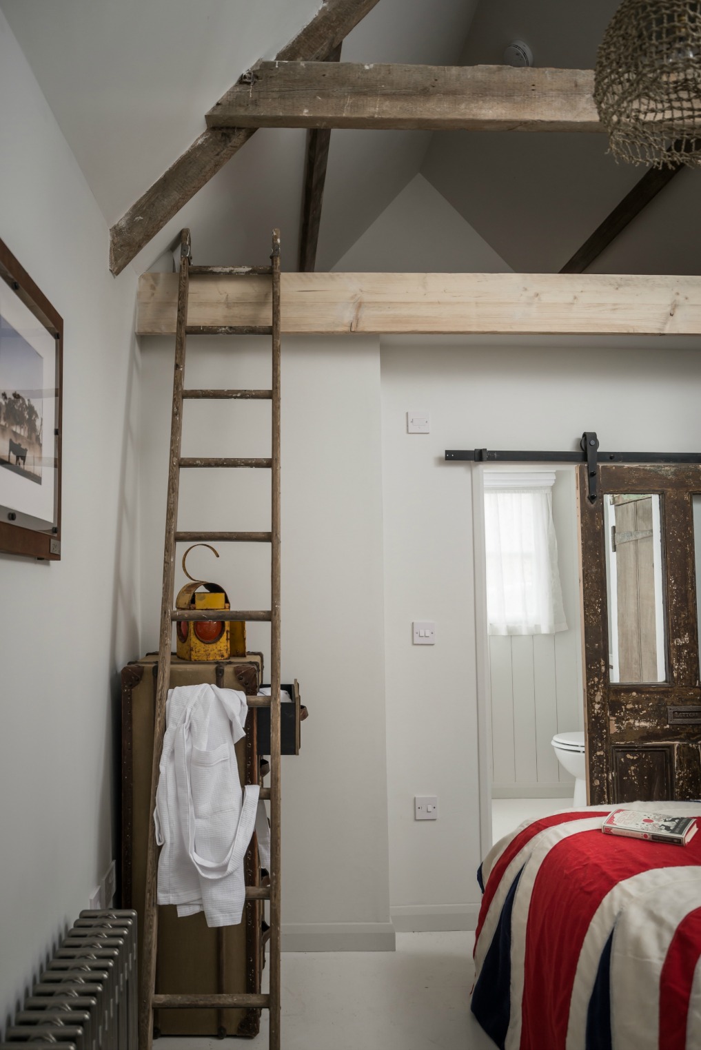 A vintage ladder leads to a loft in the bedroom kellyelko.com