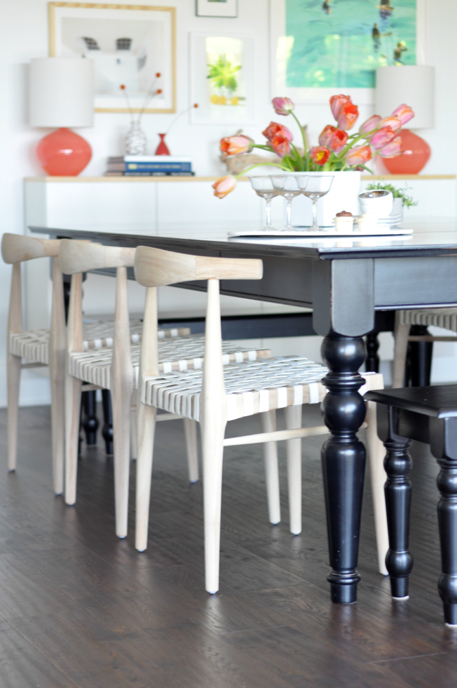 Love the woven chairs against the black dining table in this eclectic and colorful dining room 