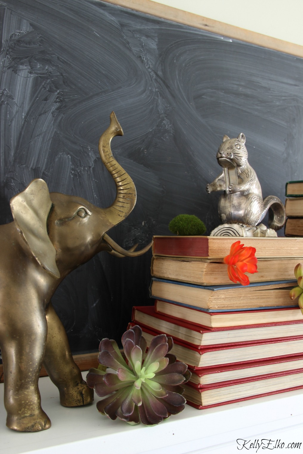 Vintage brass animals, books and a chalkboard combine in one stunning winter mantel kellyelko.com