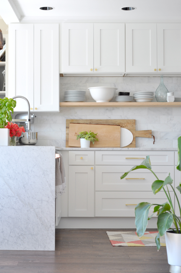 Beautiful white kitchen with marble and floating wood shelves 