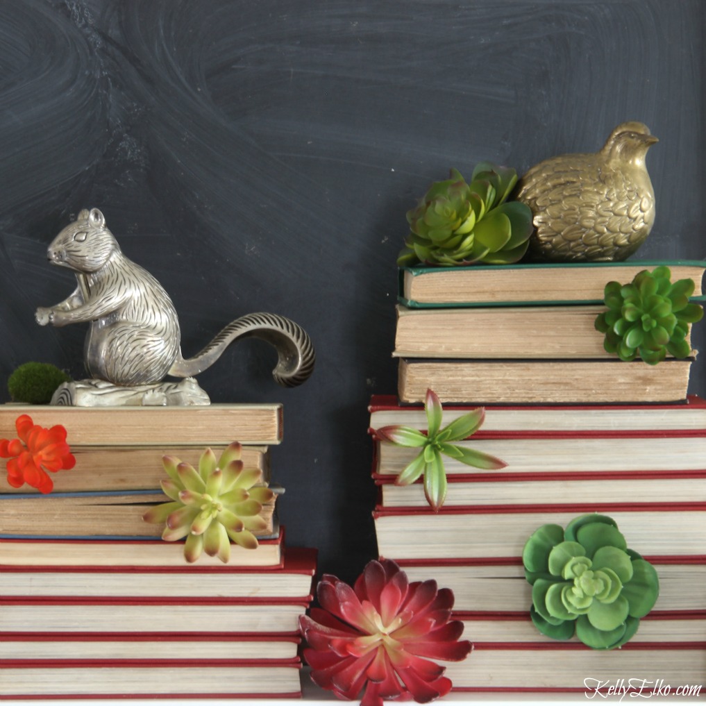 LOVE this mantel of old stacked books succulent towers and vintage brass and silver animals kellyelko.com