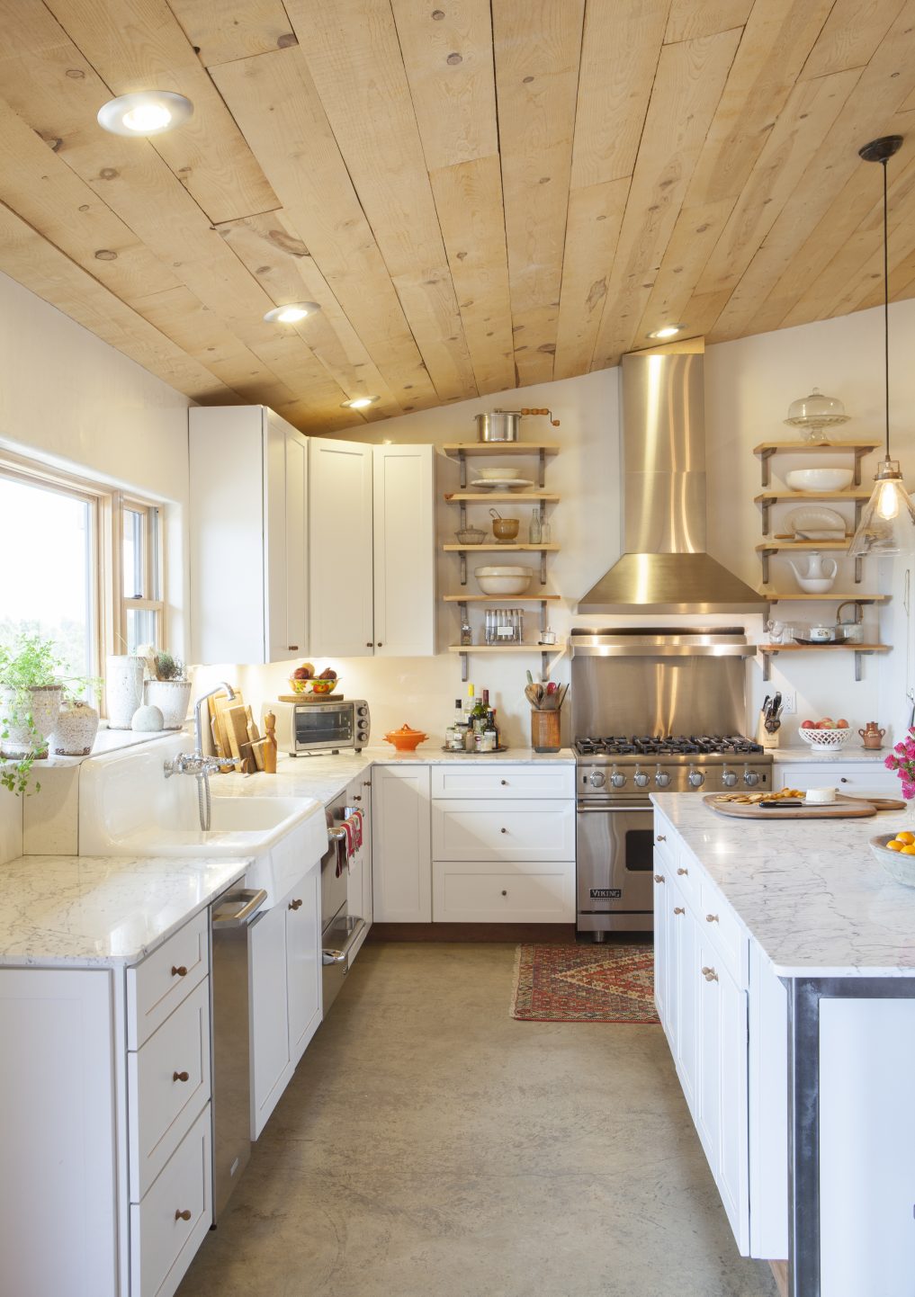 Love the hand hewn wood on the ceiling and the concrete floors of this kitchen 