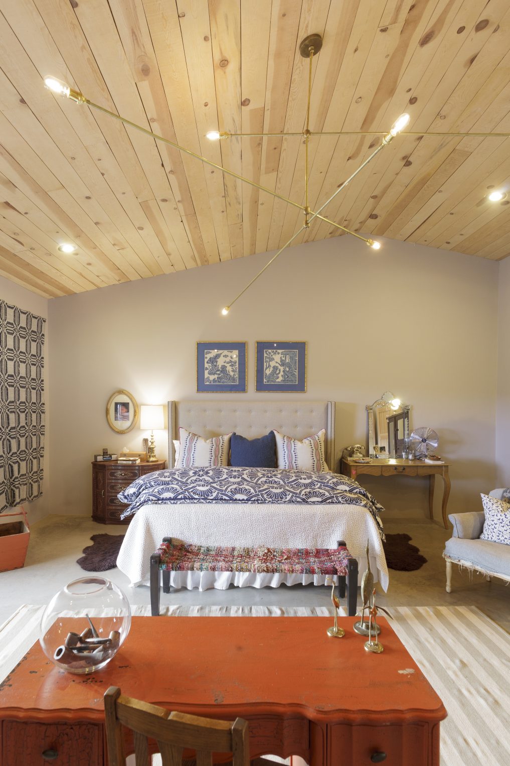 Cozy bedroom with a mix of textiles from Morocco and India and huge brass chandelier