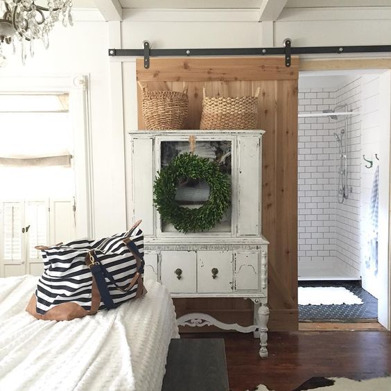 Rolling barn door separates the bedroom from the bathroom kellyelko.com