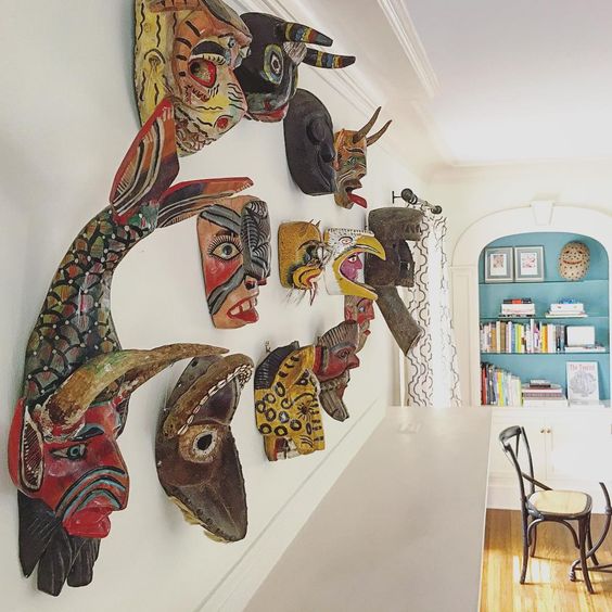 A collection of antique African masks are a fun alternative to art over a mantel kellyelko.com