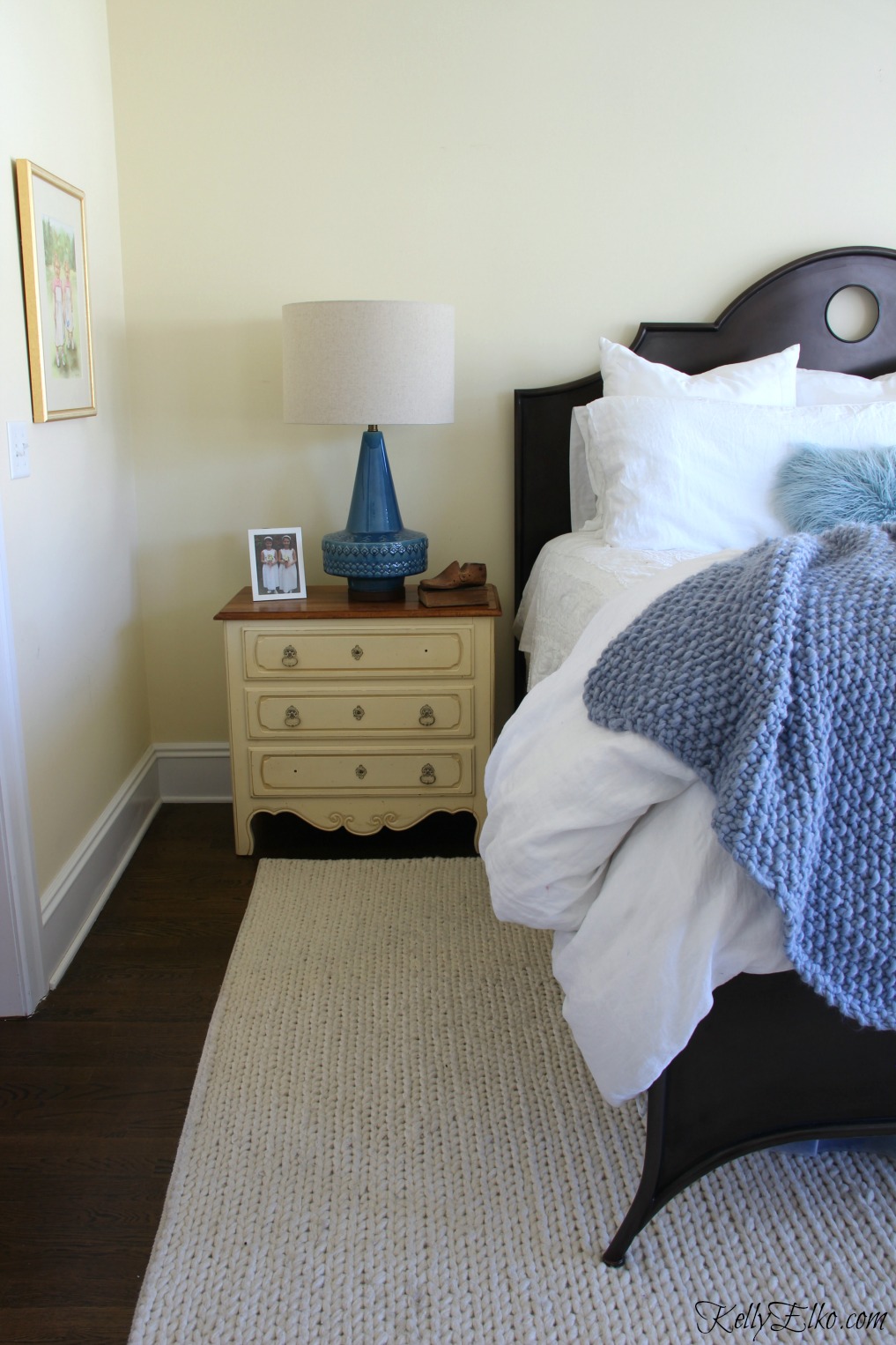 Neutral bedroom with blue accents from mid century style lamp, throw and pillows kellyelko.com