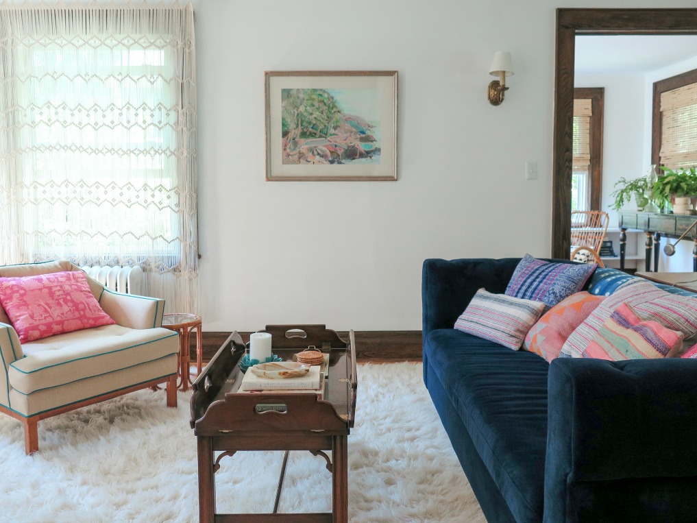 Love the navy blue Chesterfield sofa and macrame window covering