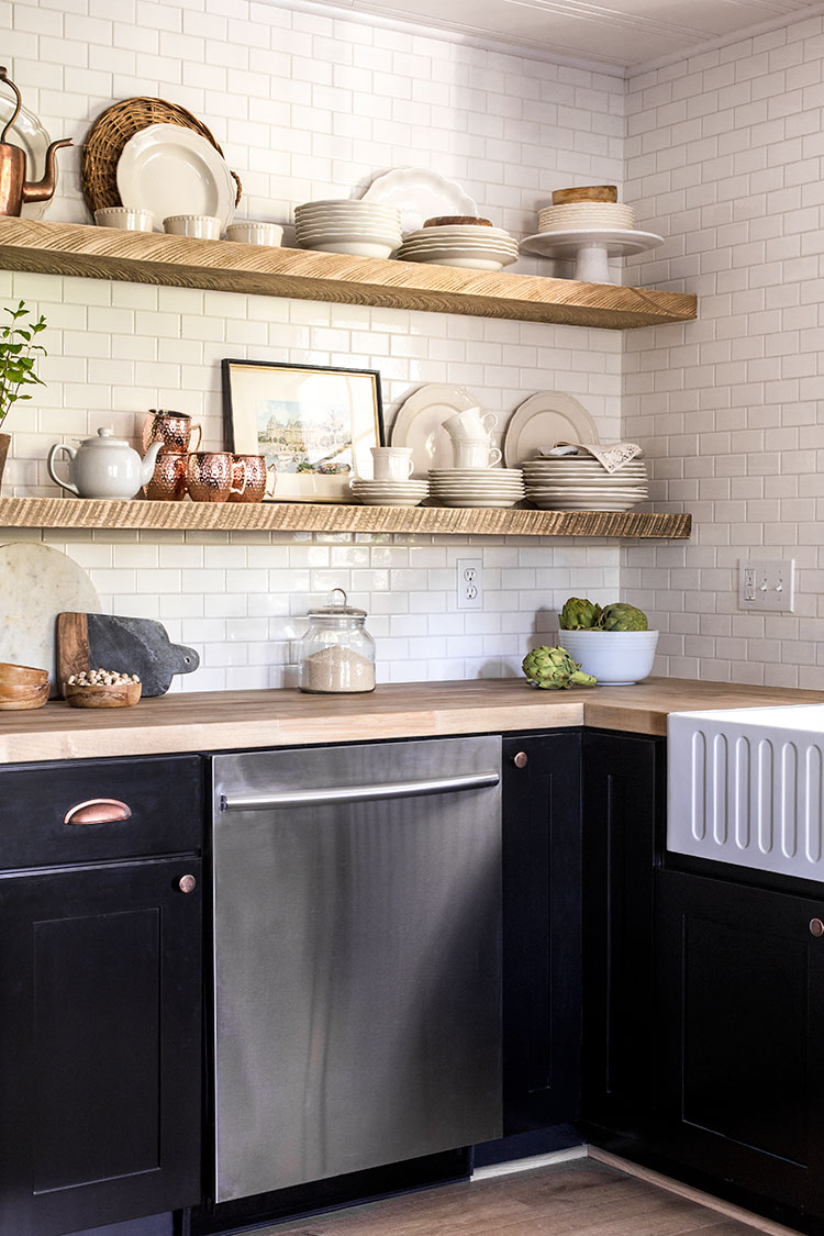 Rustic wood shelves add character to a white and black kitchen