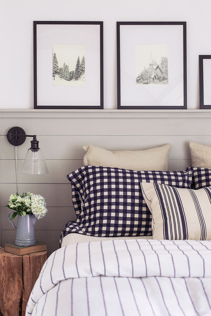 Shiplap walls and crisp striped bedding in this classic cottage bedroom