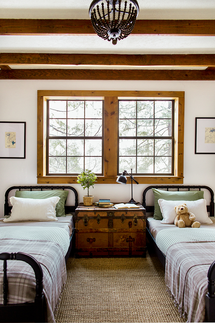 Twin beds in the kids room with an antique trunk nightstand