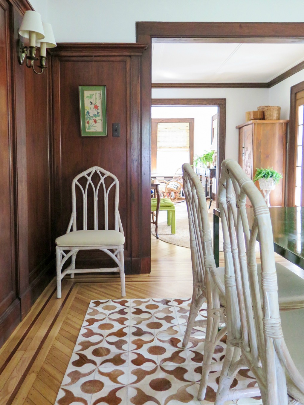 White bamboo chairs and a cowhide rug in the dining room of this 1920s home