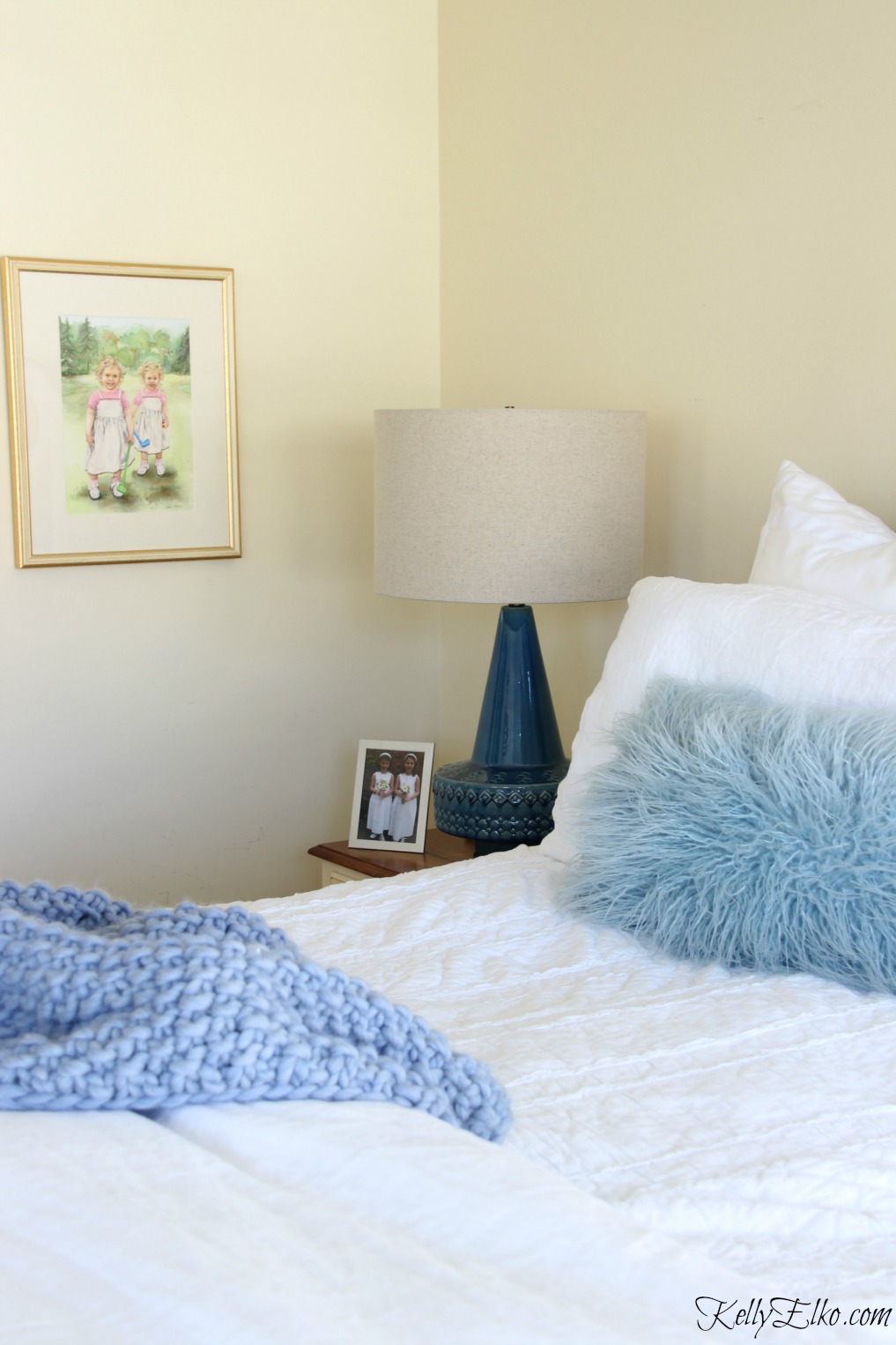 Neutral bedroom with pops of blue from lamp, throw and pillows kellyelko.com