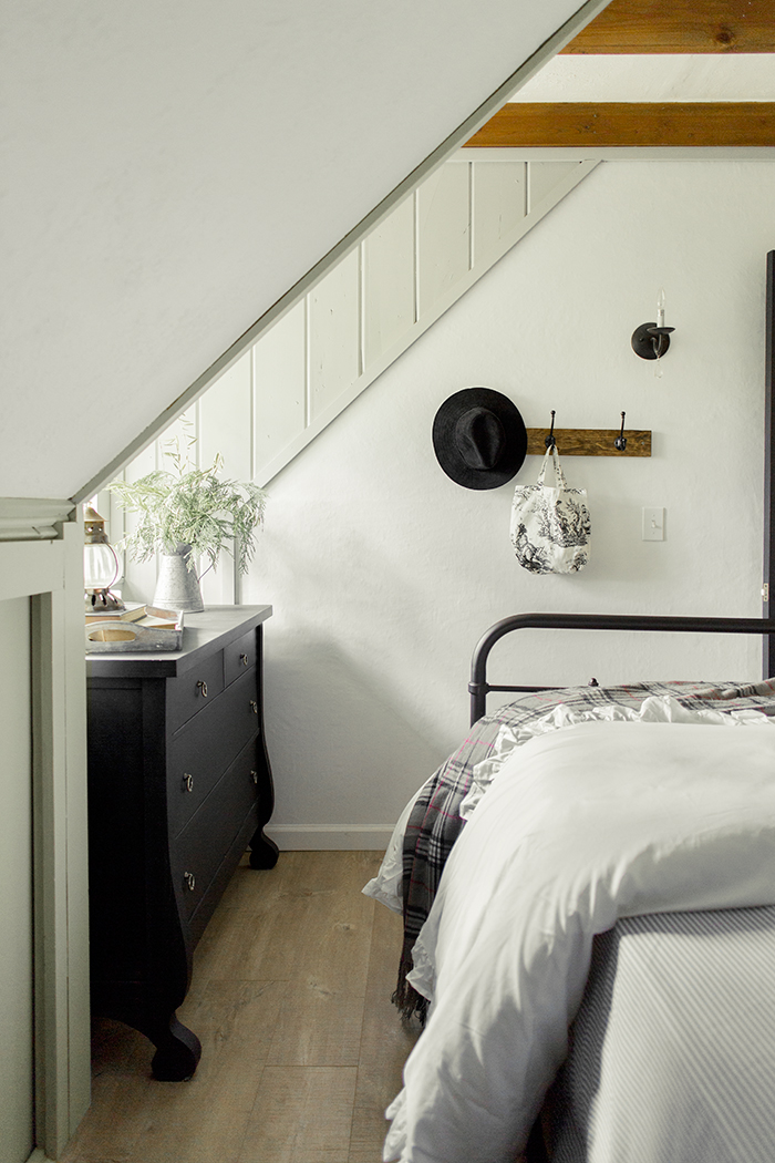 White and black bedroom with warm wood beams