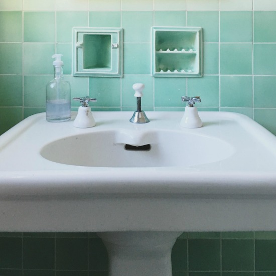 Antique green bathroom with original tile, soap holder and sink kellyelko.com