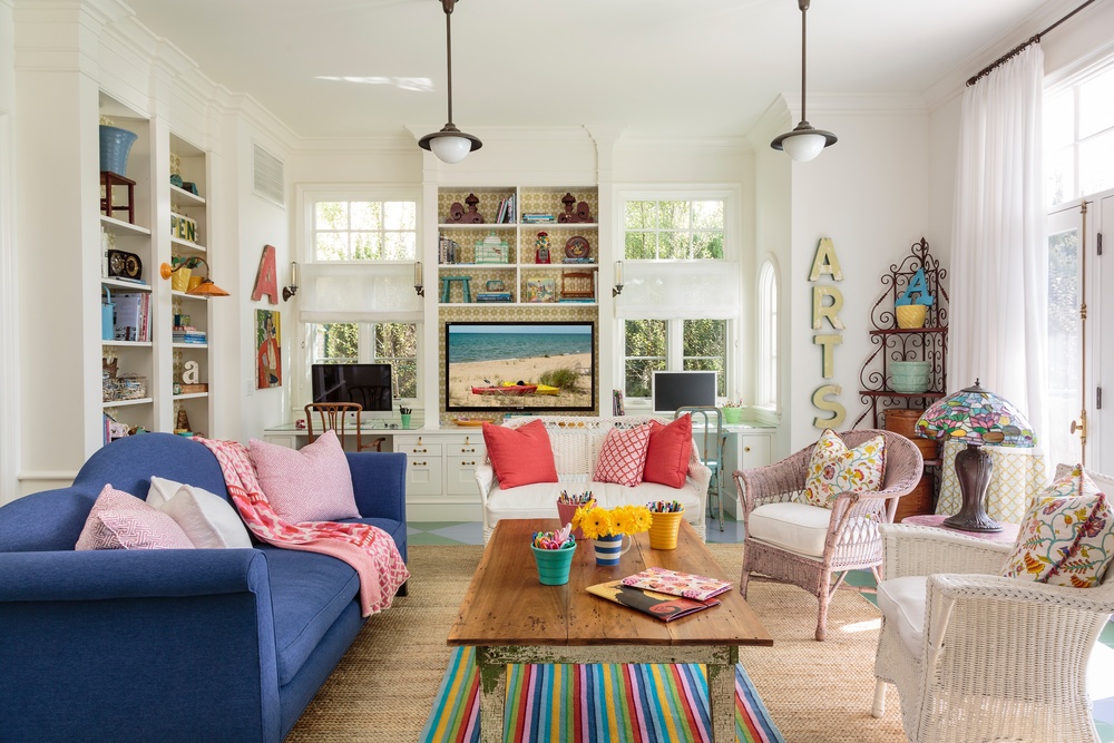 Colorful family room is grounded by white walls and neutral rug