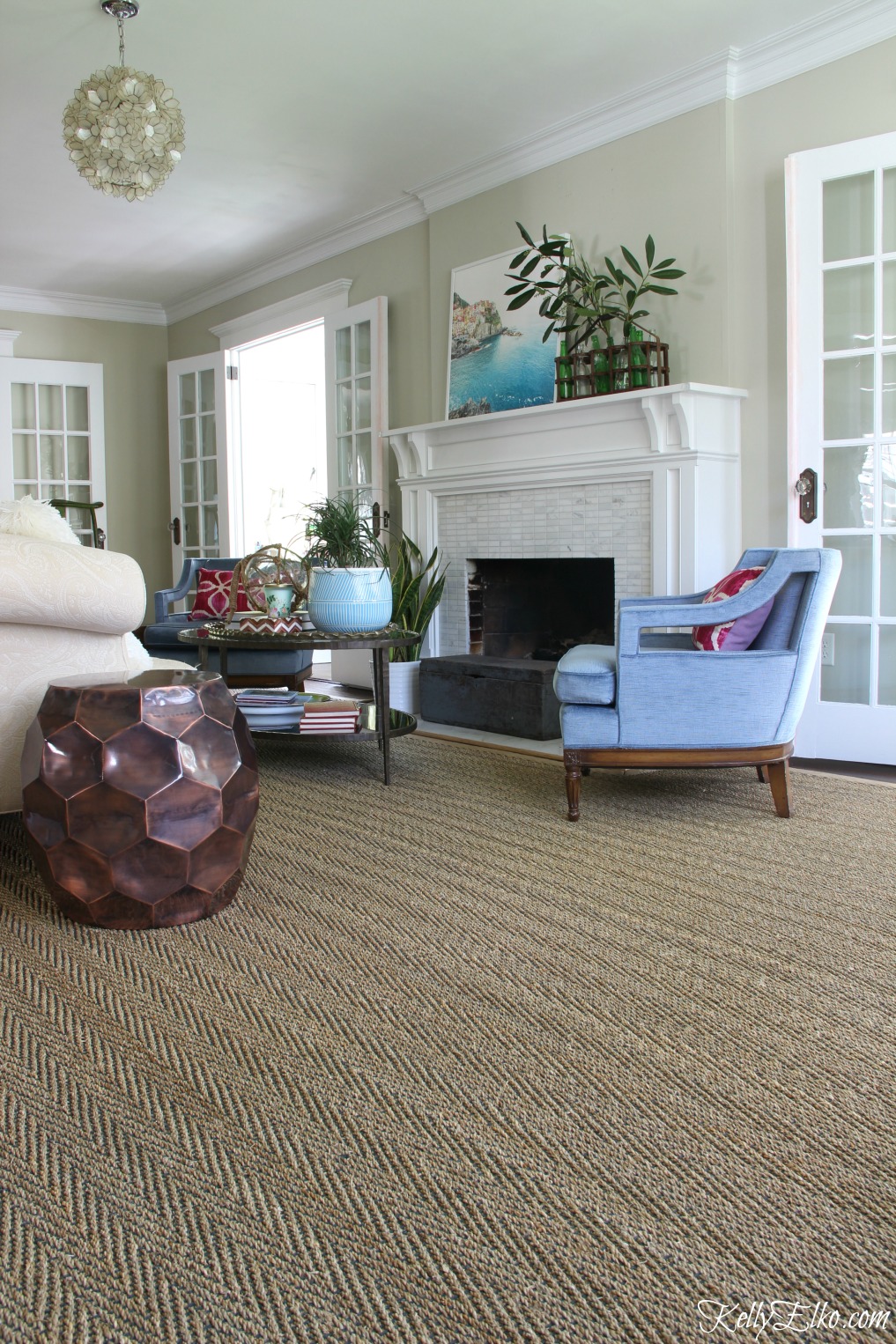 Love the three sets of French doors in this beautiful living room and the neutral seagrass rug with touches of blue kellyelko.com