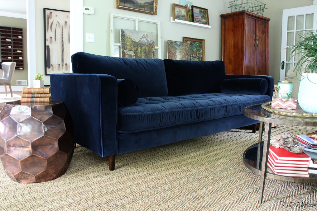 Mid century style blue velvet sofa - love this eclectic room with vintage landscape gallery wall kellyelko.com