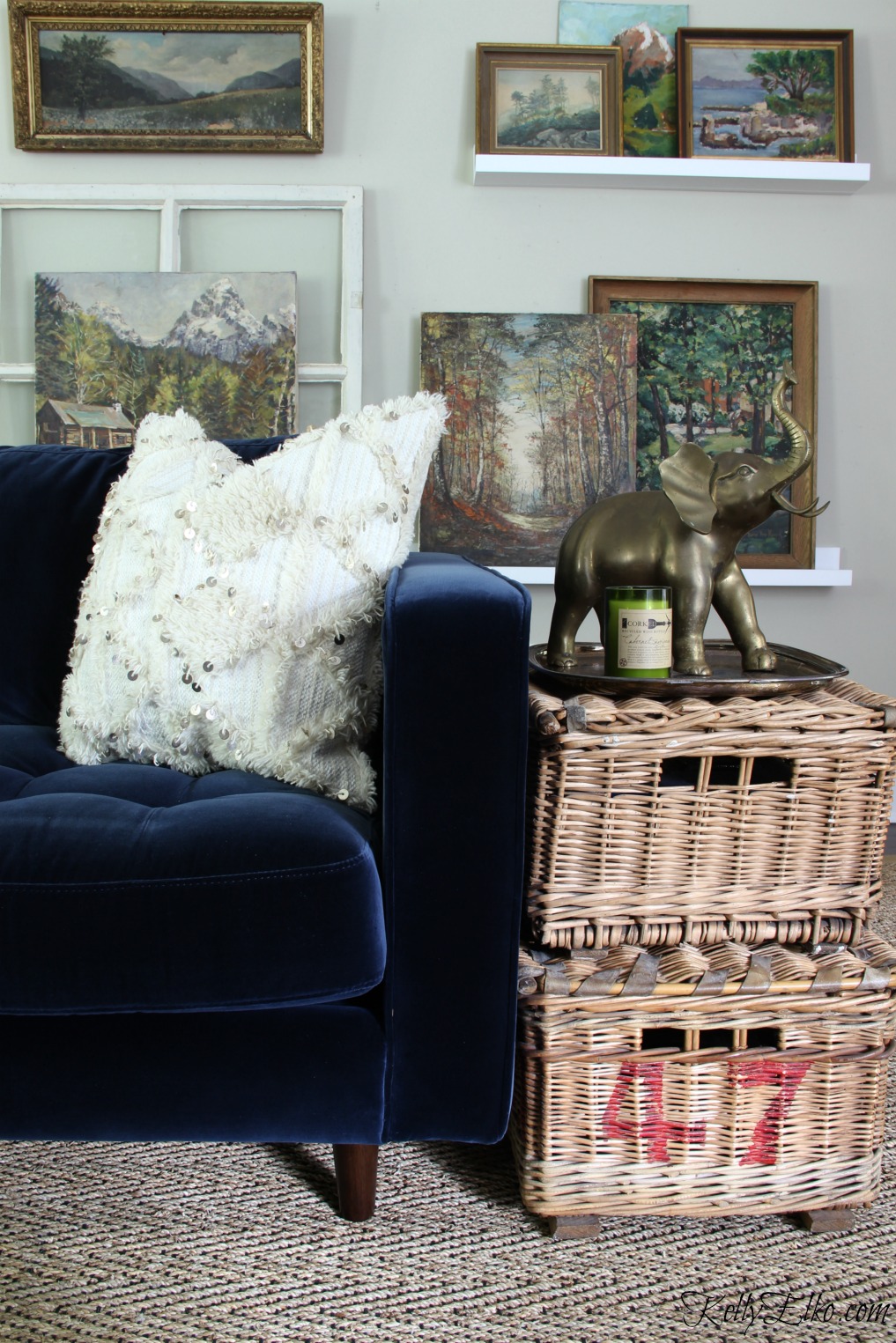 Eclectic Mix - mid century modern style blue velvet sofa, seagrass rug, vintage landscape paintings and antique wicker baskets kellyelko.com