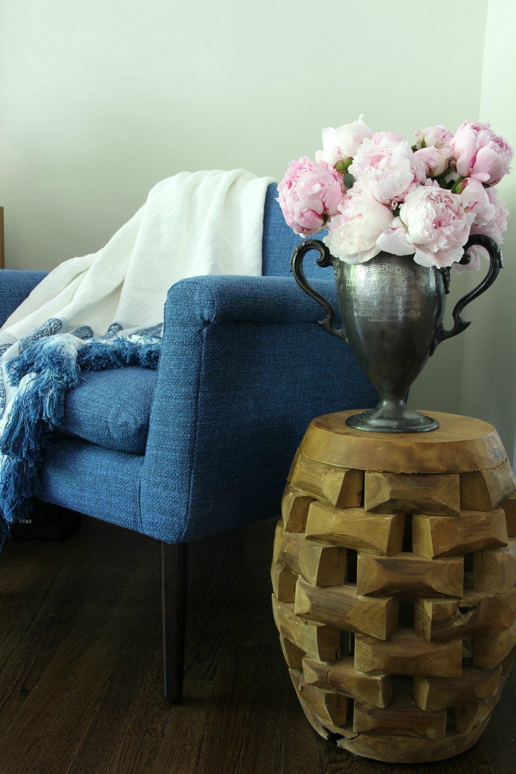 Cozy corner with blue mid chair, tassel throw and stunning bouquet of pink peonies kellyelko.com